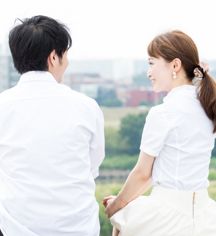 河原に座って話すカップル